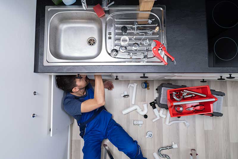 Hardy Plumbing technician installing a new kitchen sink